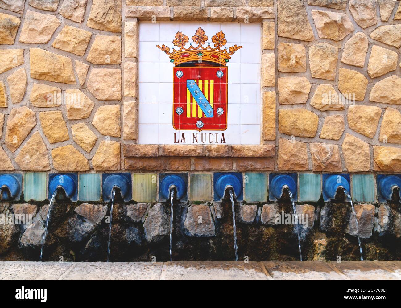 Polop de Marina, Costa Blanca, Spain - 3 Otober 2019: Water fountains with a flag emblem of La Nucia on tiles in the village public park Stock Photo