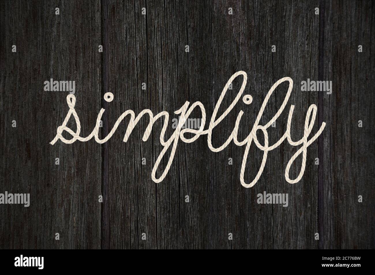 close up of word simplify rope text design on black wood grain Stock Photo