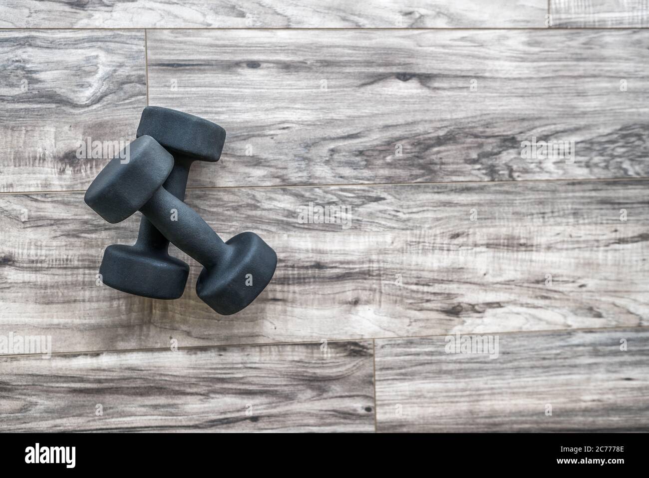 Training at home fitness concept: dumbbell weights on wood floor at fitness gym . Weight loss and health. Sport fit lifestyle Stock Photo