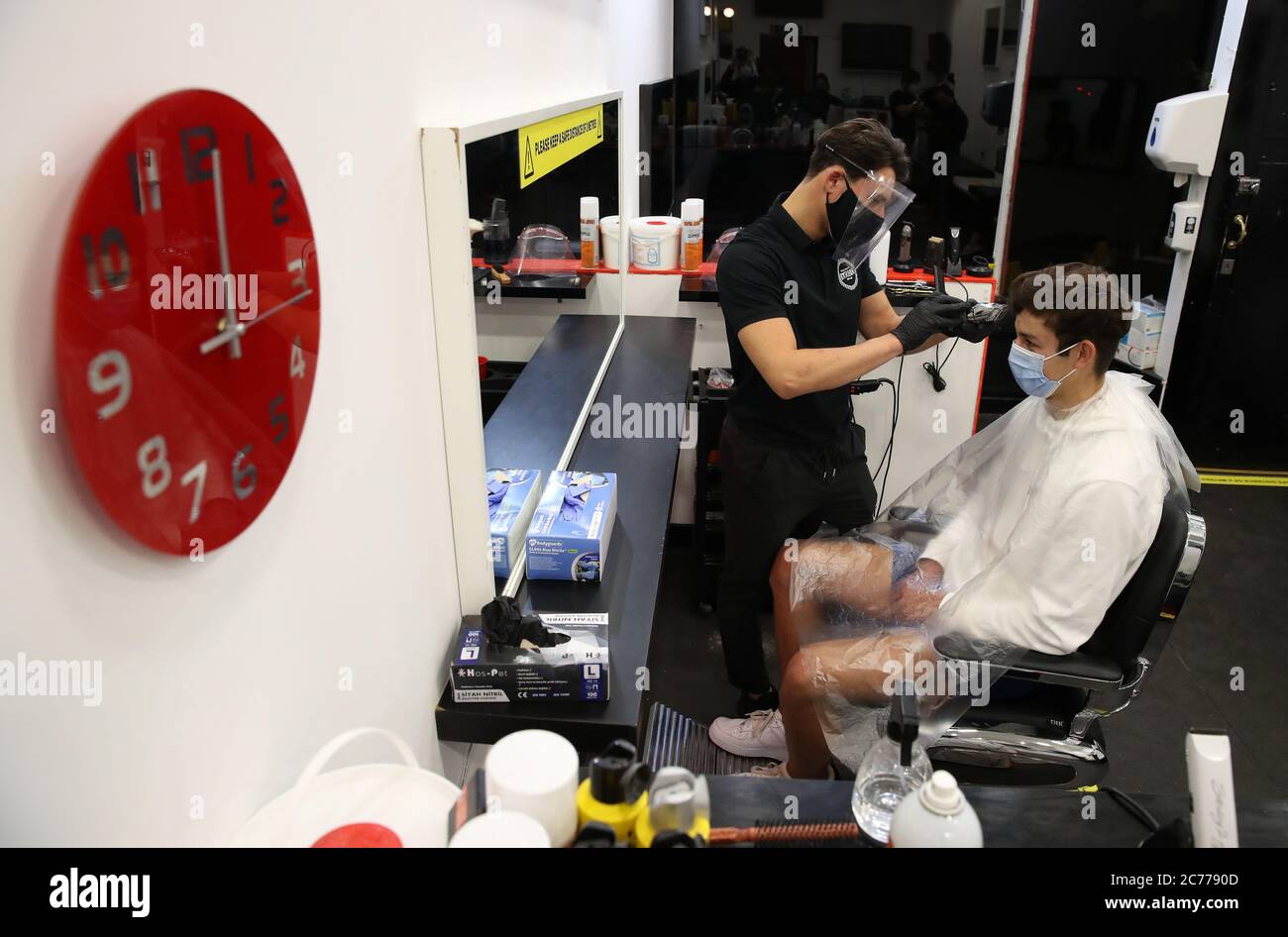 Barber Tony Mann with first customer Mitchell Wildman in the chair at