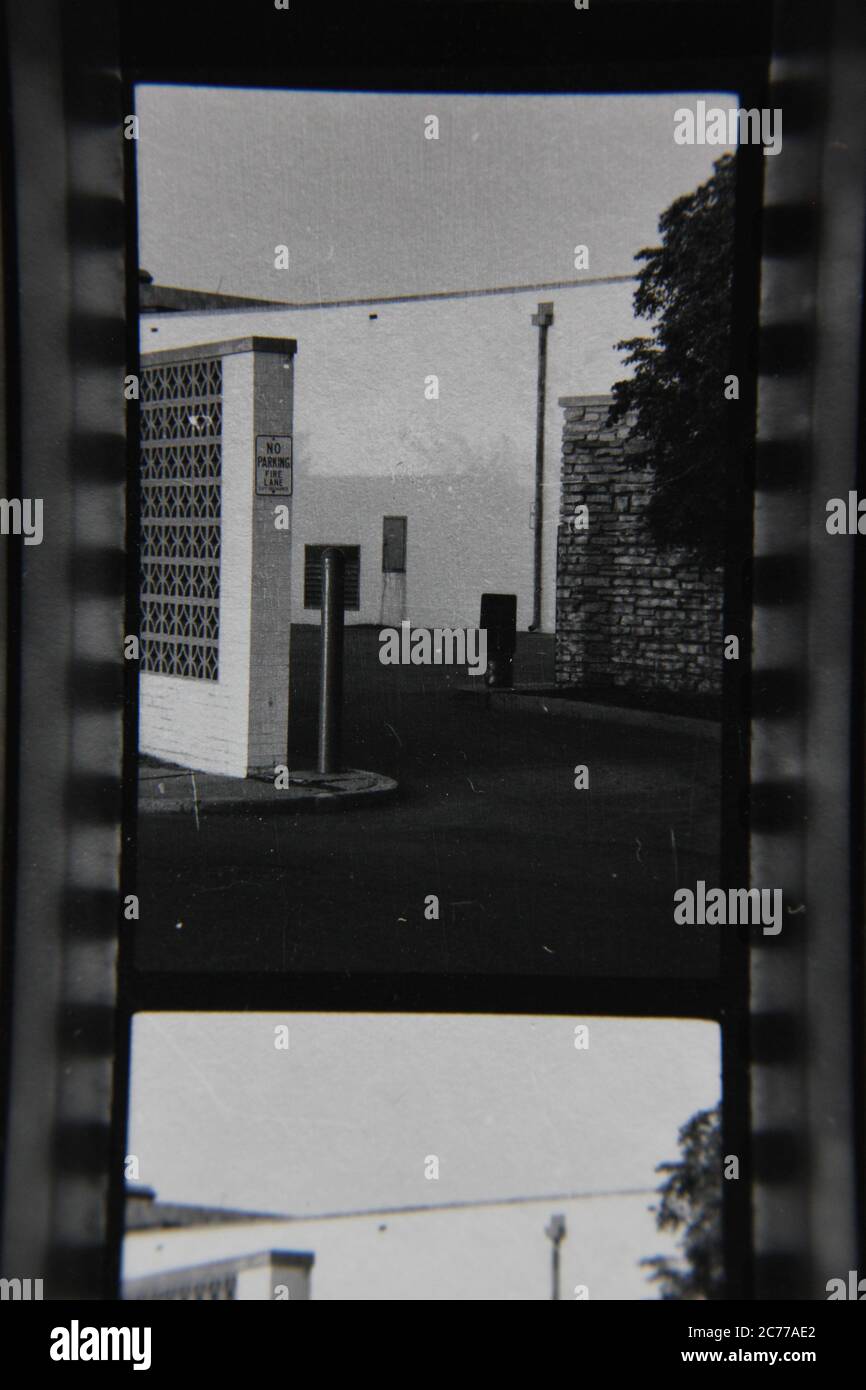 Fine 70s vintage contact print black and white photography of a back door loading area behind a privacy fence. Stock Photo