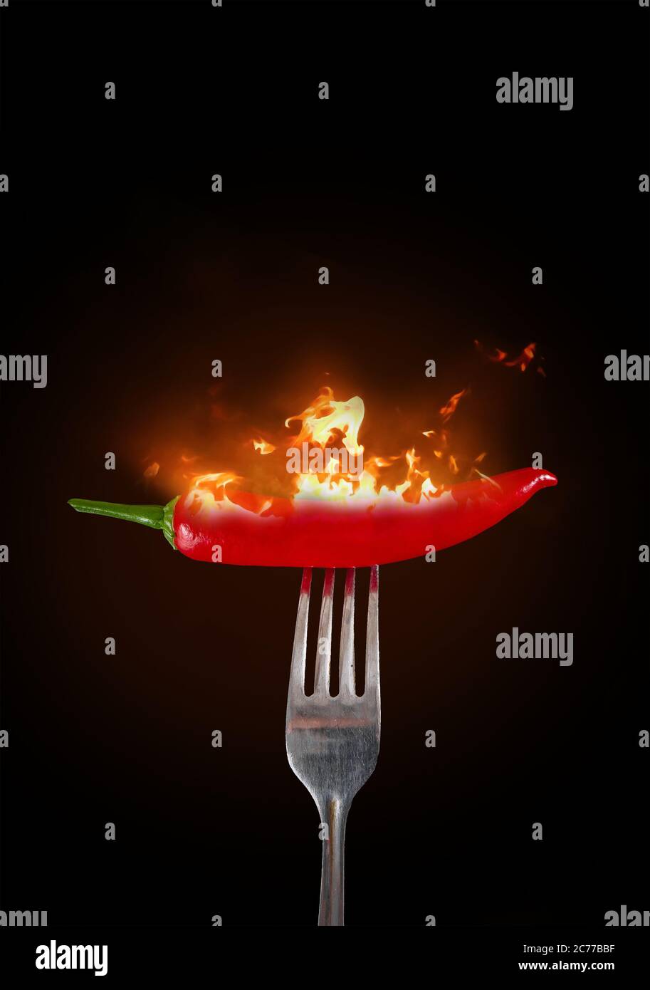 Red chili peppers on a fork in flame. Hot red chili peppers on a fork