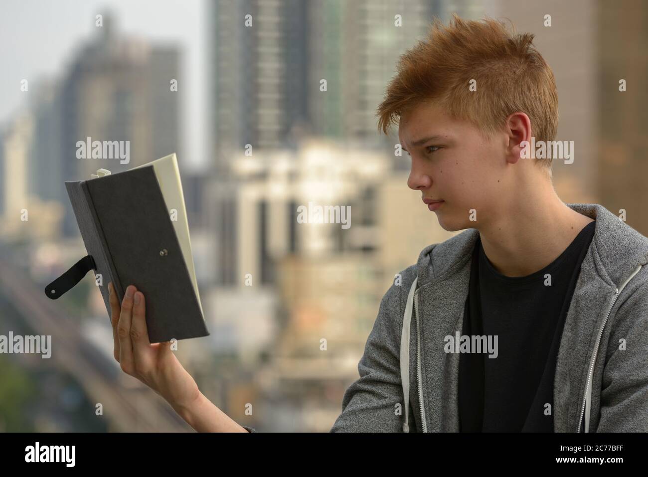 Young handsome teenage boy against view of the city outdoors Stock ...