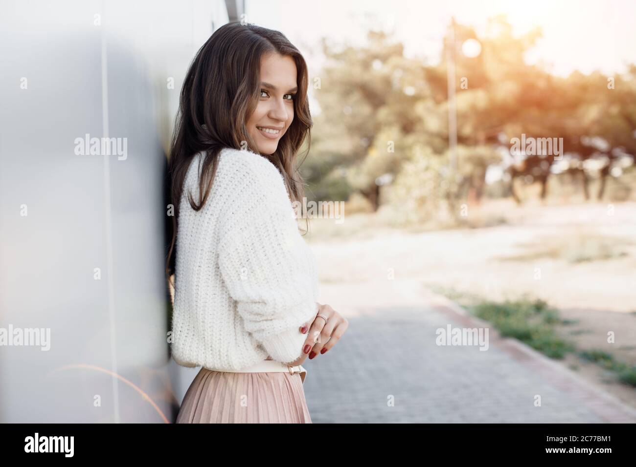 Portrait of a young smiling woman near wall outdoor Stock Photo