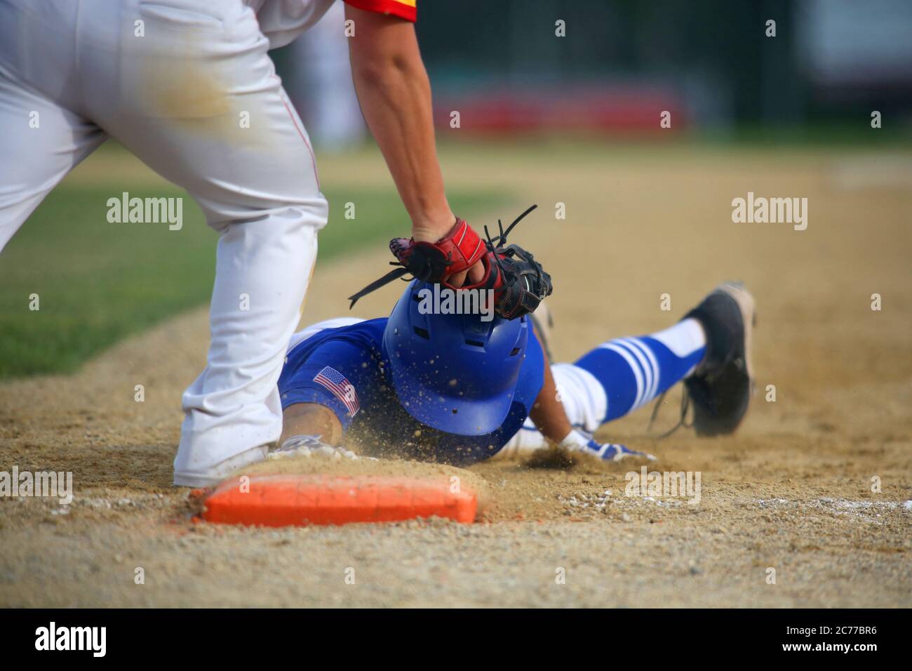 A baseball first baseman tags a base runner out on a pick-off play in a close-up image with space for copy in the upper right of the frame. Stock Photo
