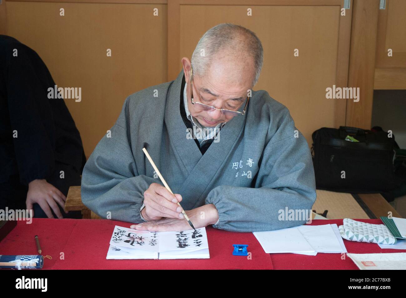 A Japanese calligrapher inscribes characters on a scroll at Kamakura, outside Tokyo. Stock Photo