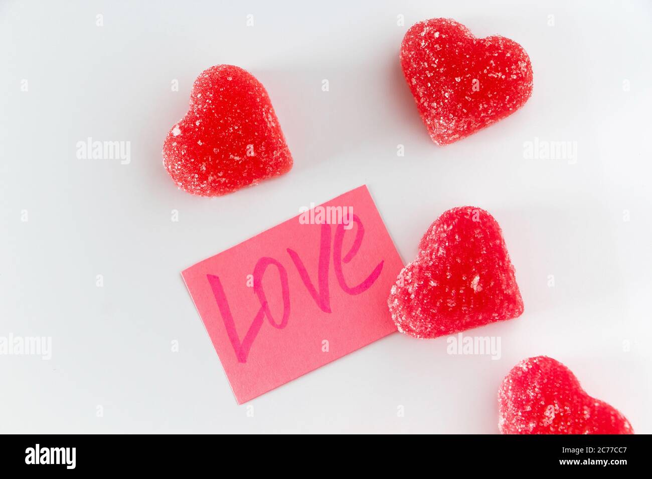 Pink sticker with the word love and red fruit jelly in the shape ...