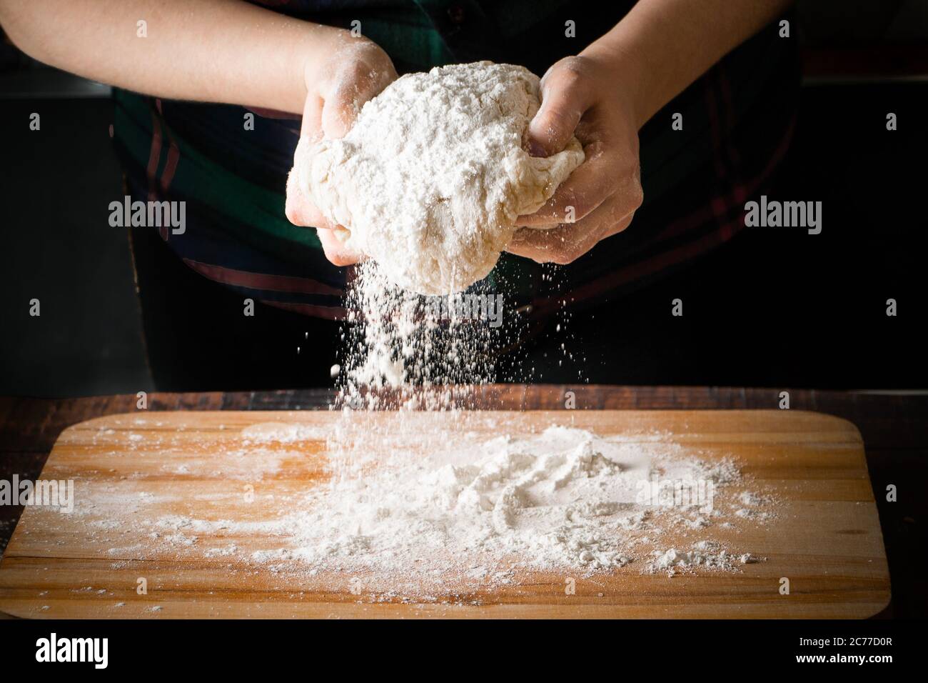 The process of making pizza dough, female hands knead flour Stock Photo