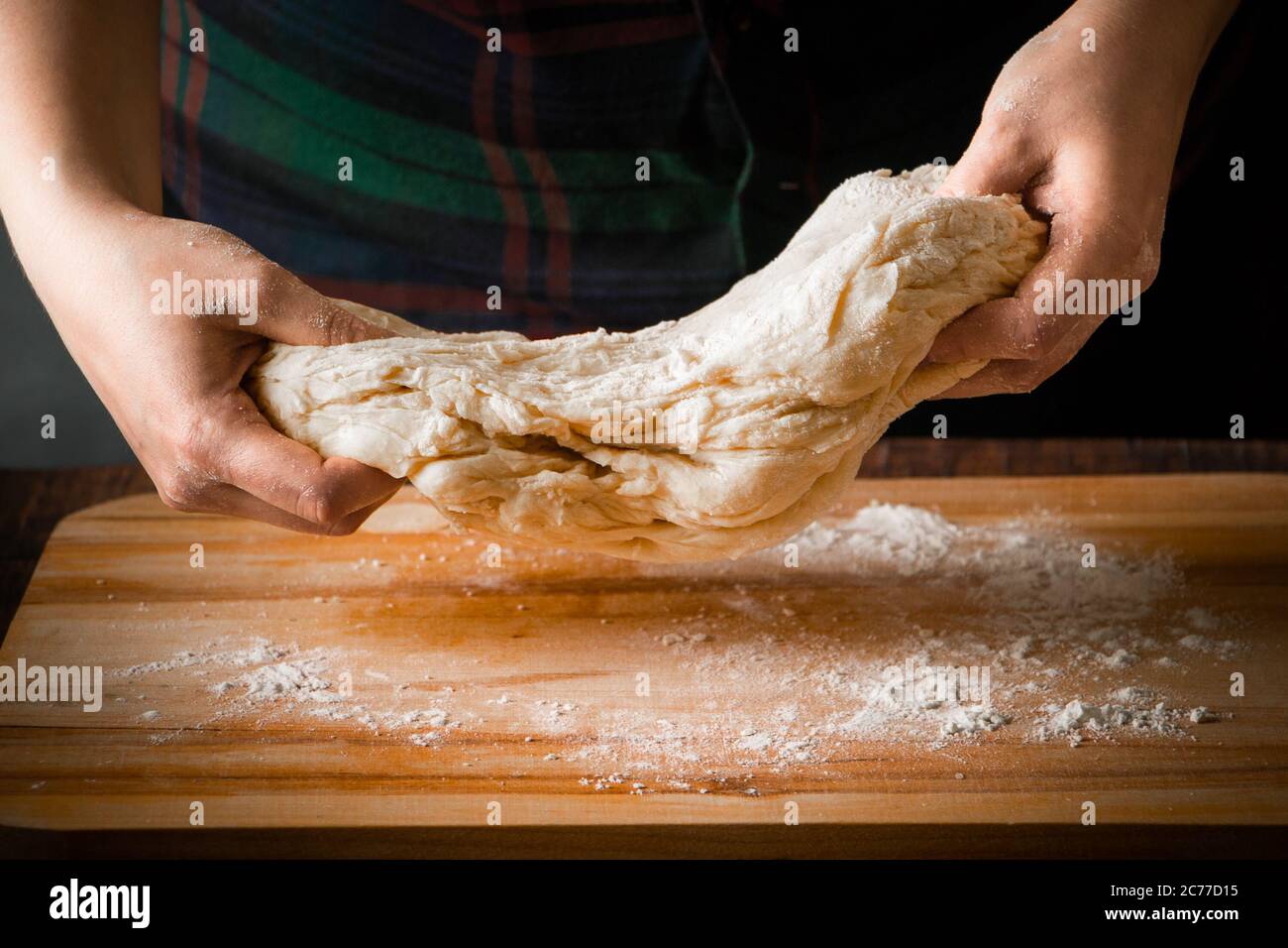 Elastic pizza dough in the hands of a woman chef Stock Photo Alamy