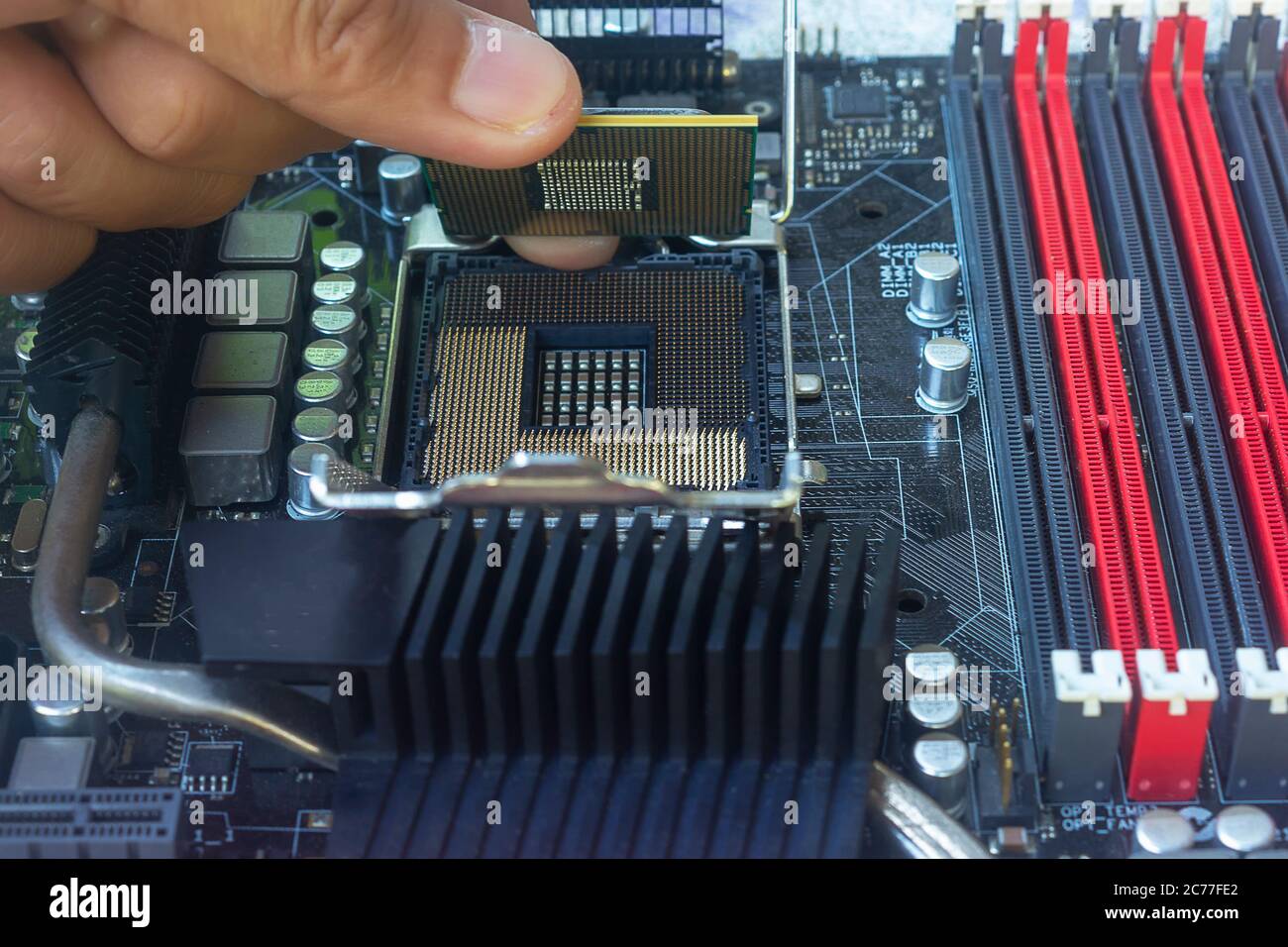 Close up hand of technician putting CPU on the socket of computer motherboard Stock Photo