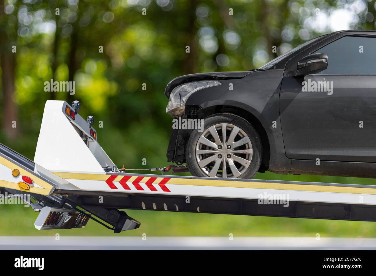 accident Car Slide on truck for move. Black car have damage by accident