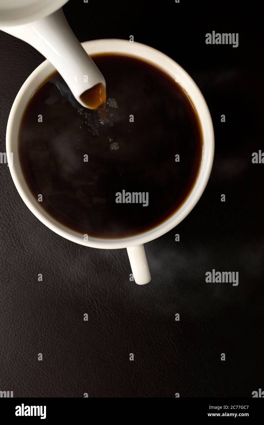 Top view pouring the black coffee from pot into cup Stock Photo Alamy