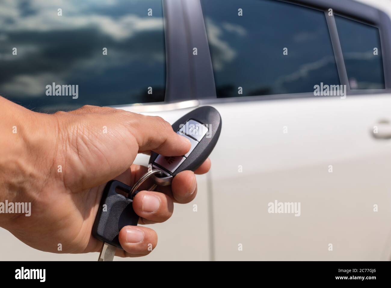 Hand man hold button unlock on the car remote control for unlock door