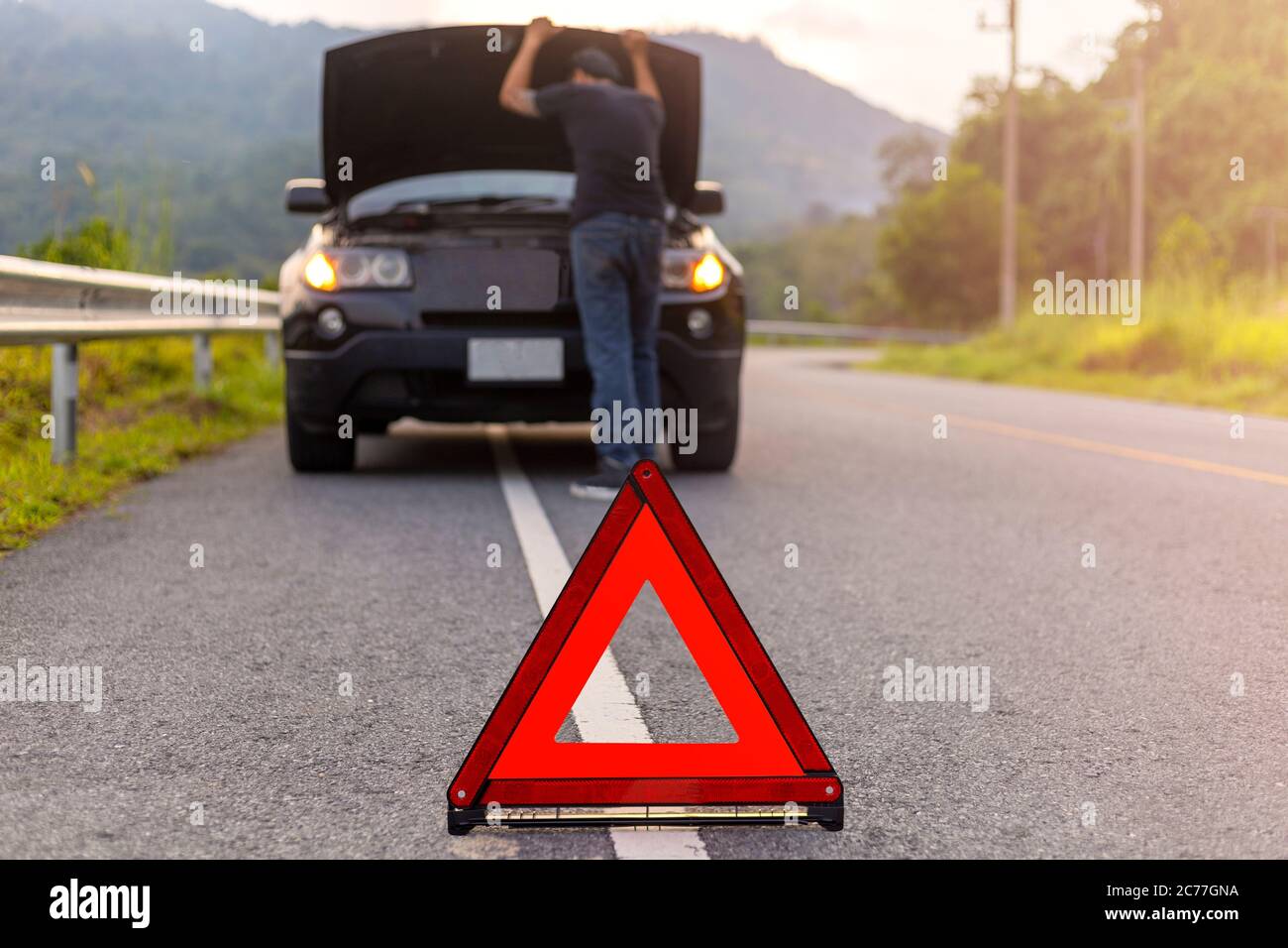 Red triangle sign on road for warning have car with breakdown open car