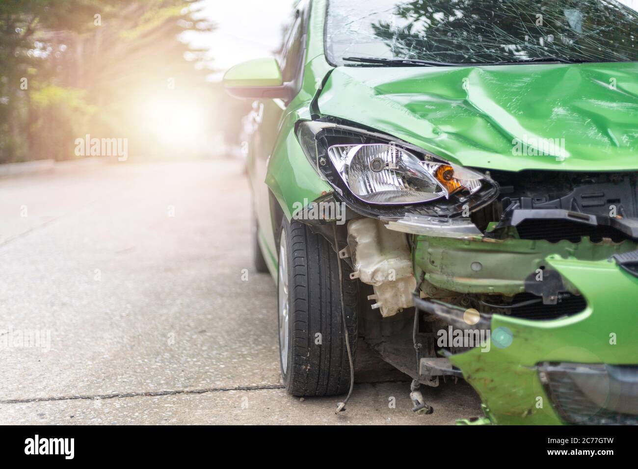 Front of green color car damaged and broken by accident on road parking can not dirve any more Stock Photo
