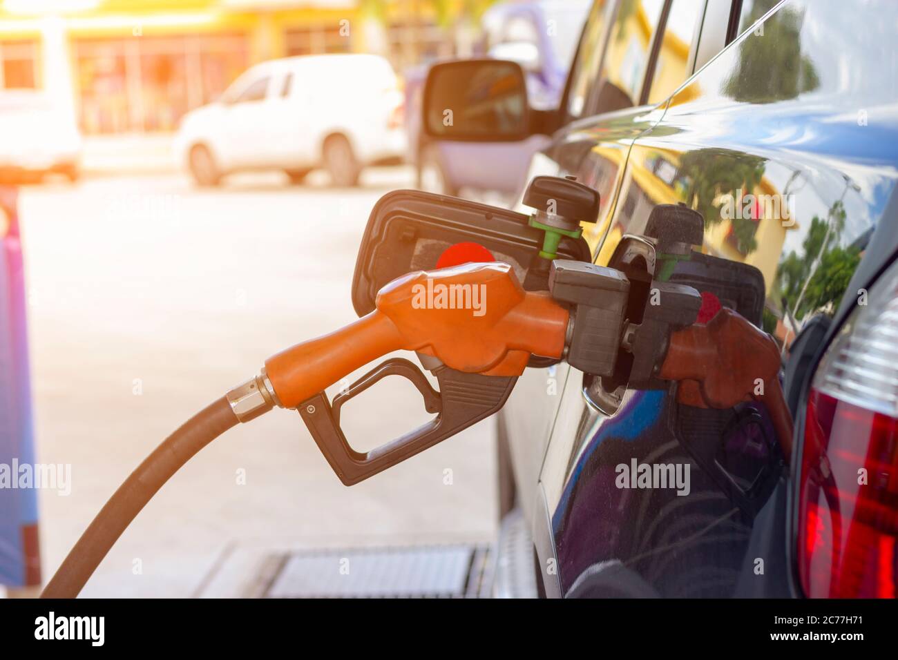 fuel nozzle. Filling gasoline to black car at gas station Stock Photo