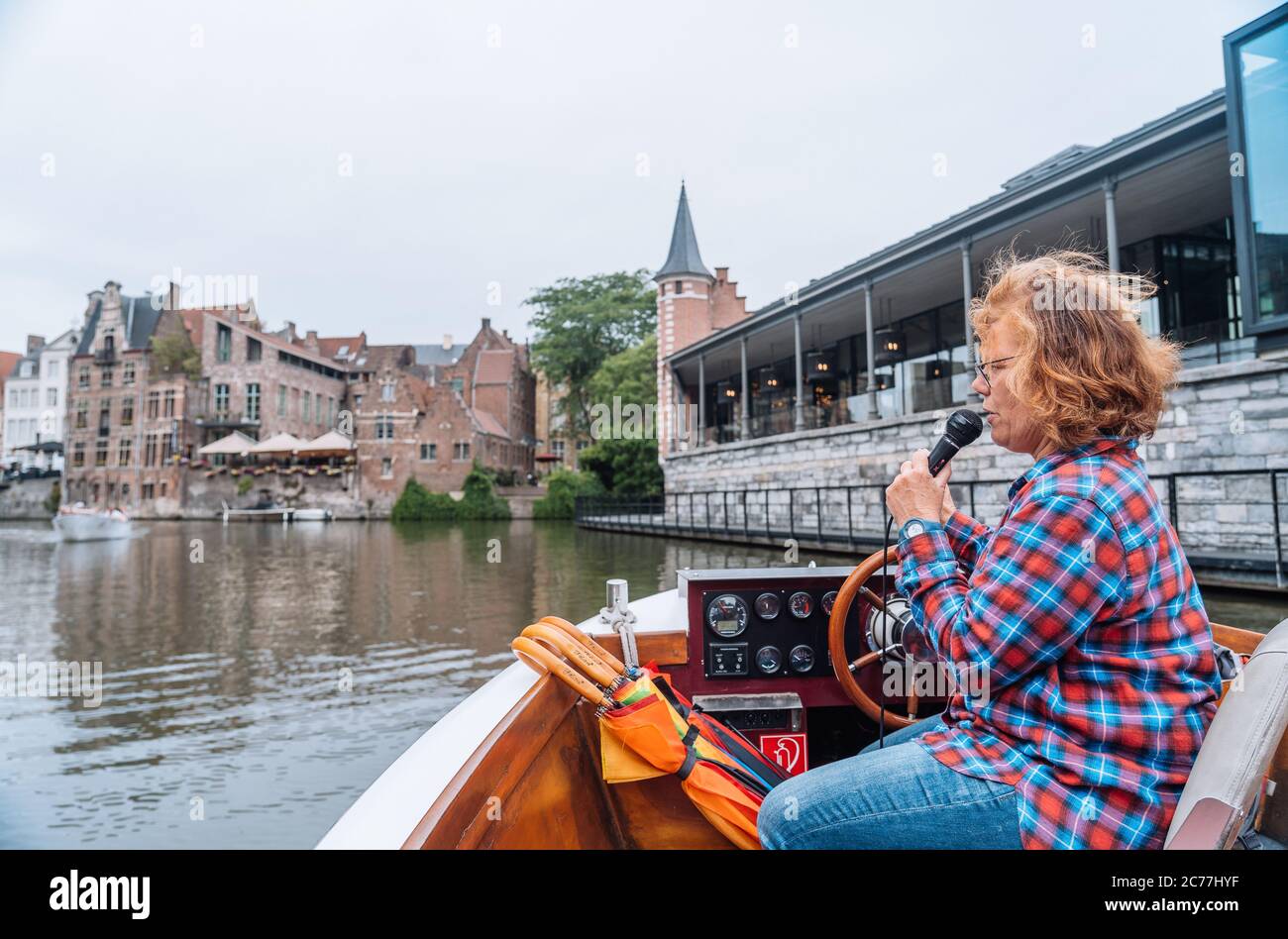 A woman tour guide on a boat talking a the stunning architecture of Belgium Stock Photo