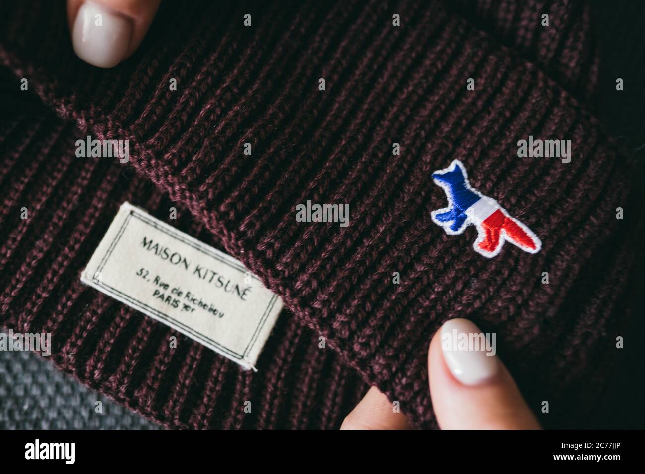 Closeup of Maison Kitsune logo label on green background Stock