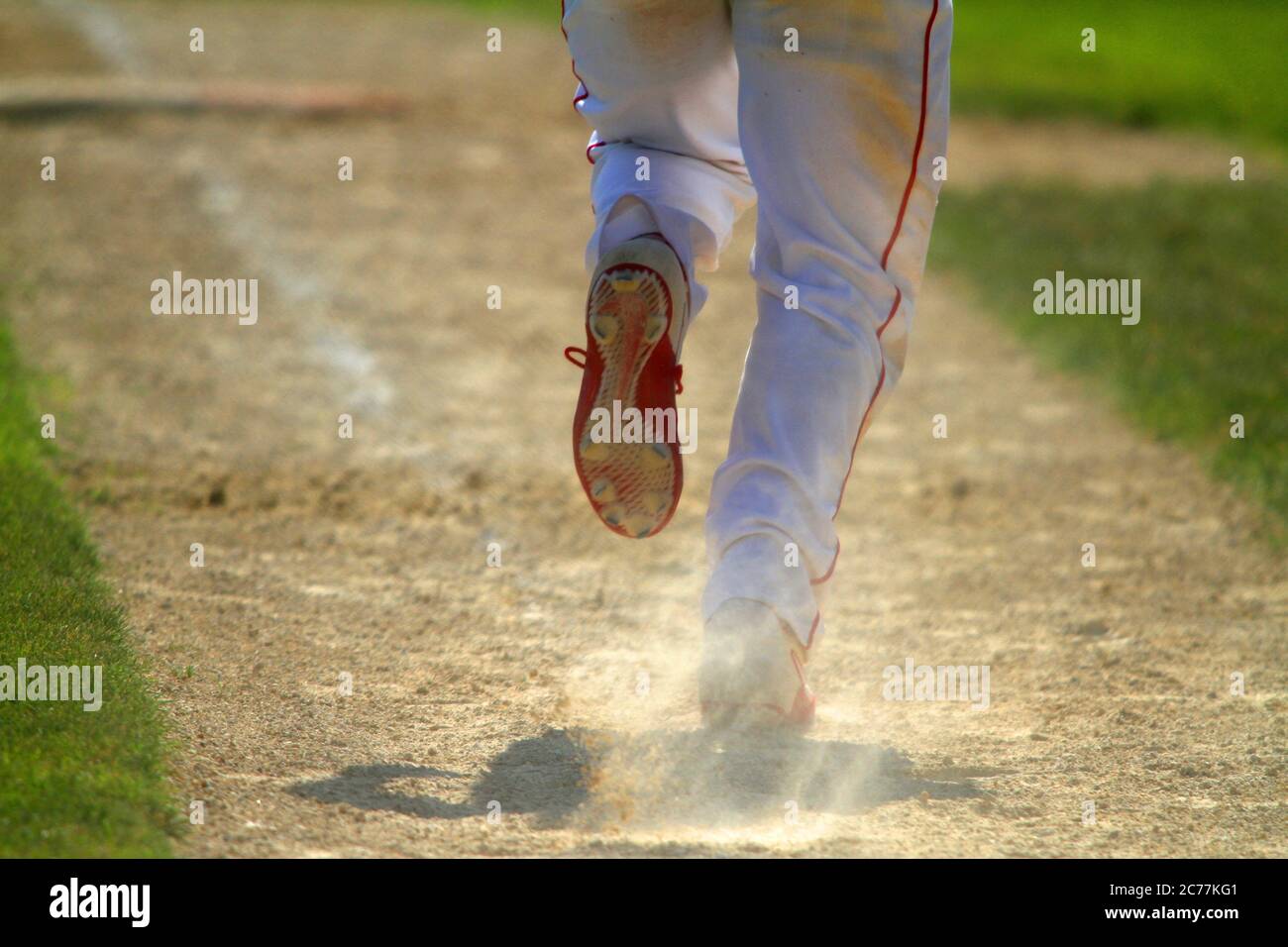 A baseball player breaks out of the batters box after hitting the ball. Stock Photo