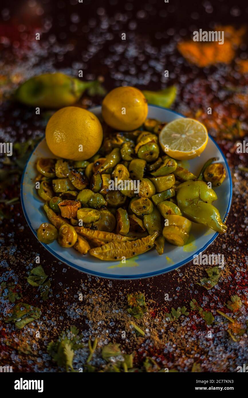 Close up shot of traditional ivy gourd or tindora salad in a glass plate with all of its constituent ingredients with it on a brown colored wooden sur Stock Photo