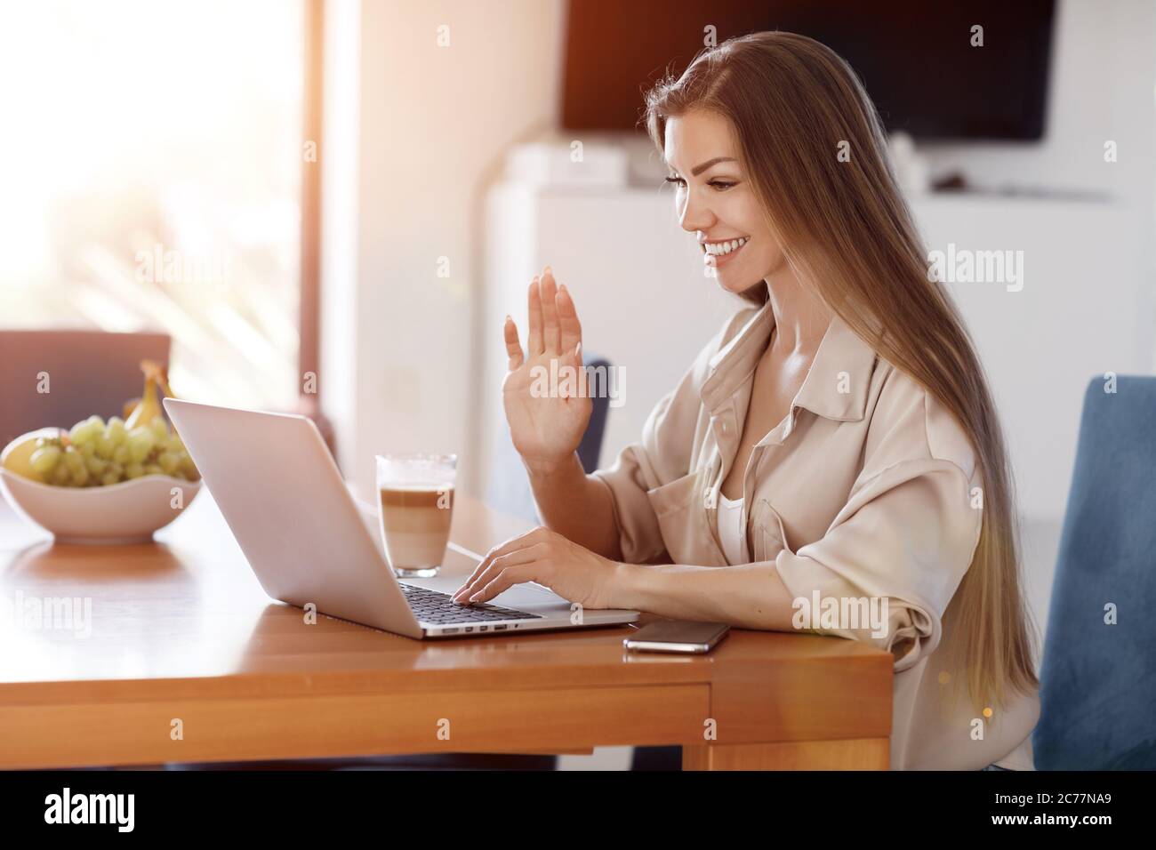 Pretty young woman working at home with laptop Stock Photo - Alamy