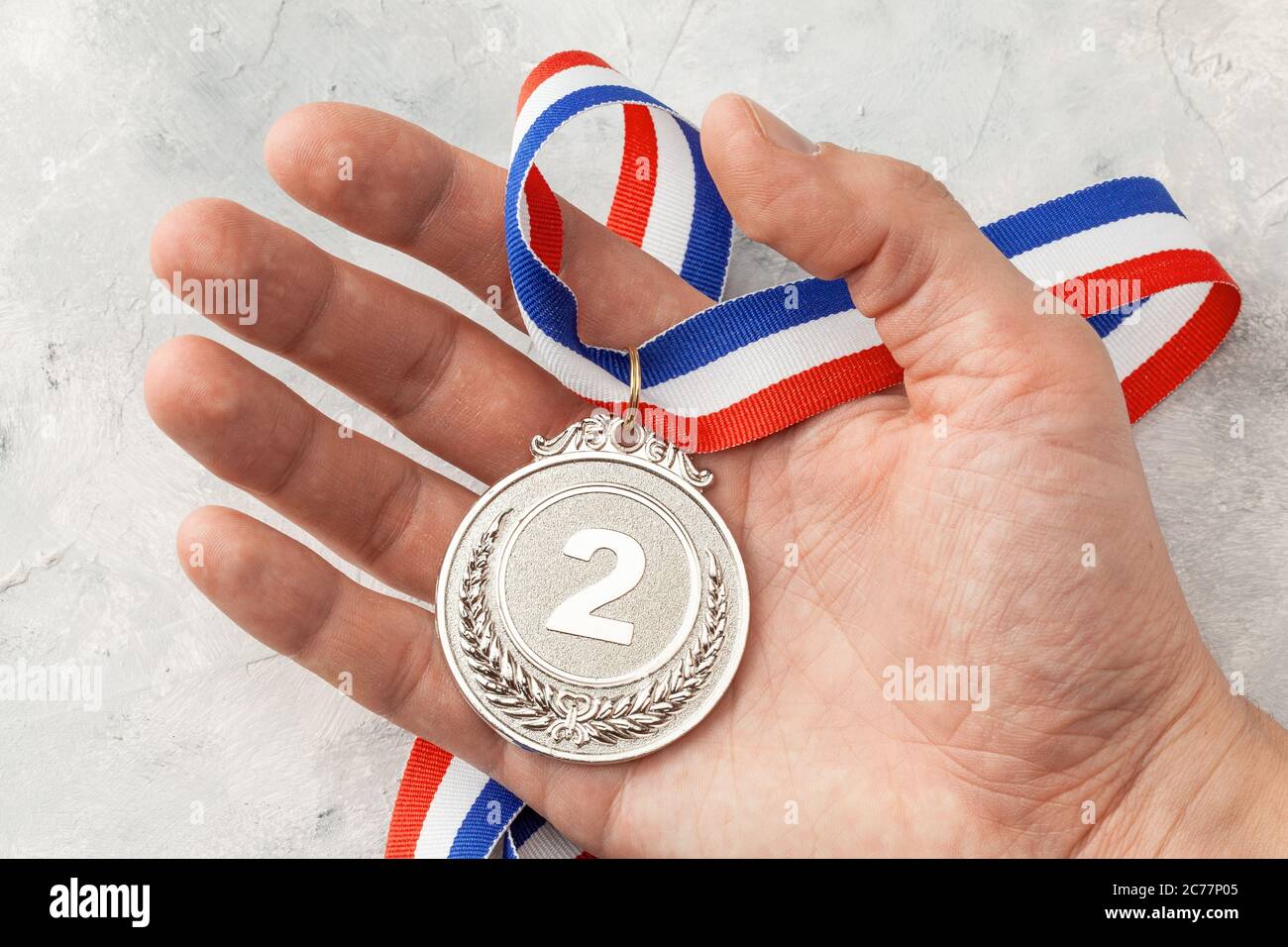 Silver Medal The Second Place Award With A Ribbon A Man Holds In His Hand Stock Photo Alamy
