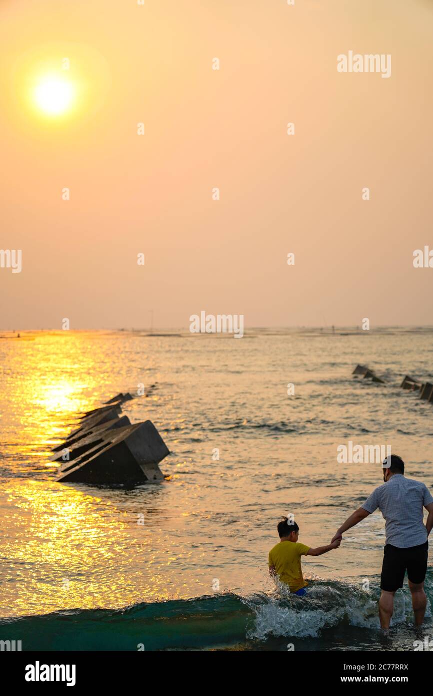 Happy asian family playing at the beach hi-res stock photography and ...