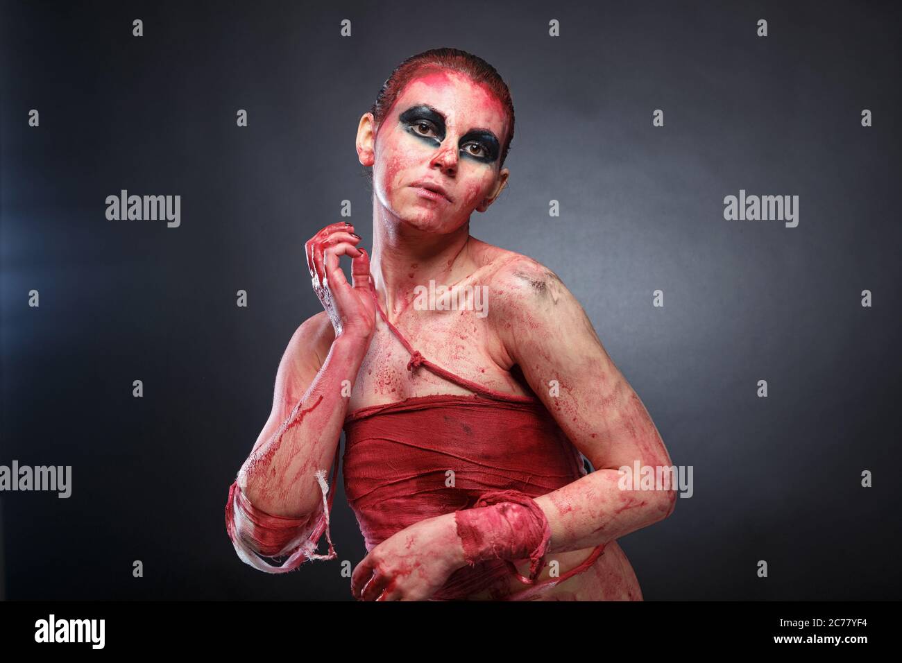 Photo of young girl in fake blood on grey background Stock Photo