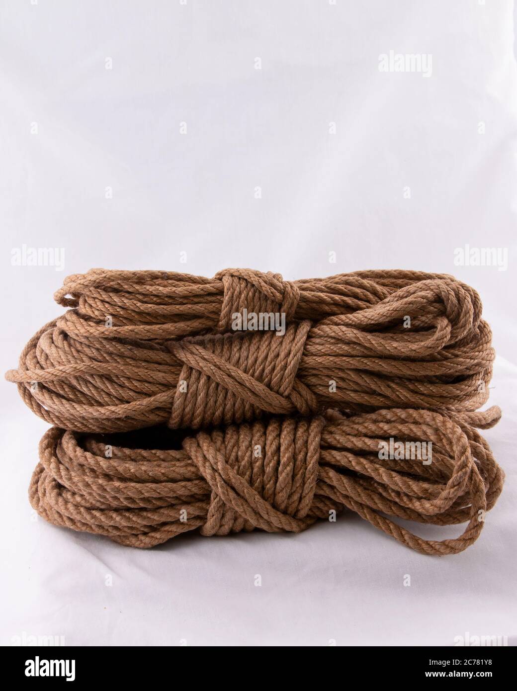 Coiling jute rope starting with ends and bight locked with tuck under wraps Stock Photo