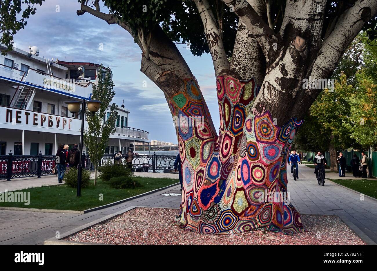 Russia,Astrakhan Oblast. Yarn bombing on a tree, showing different knitted and crocheted panels stitched together on the quays of the Volga in Astrakhan city Stock Photo