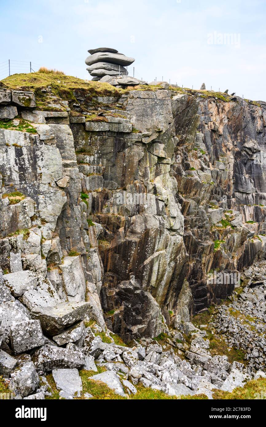 The Cheesewring natural rock formation seems to be balanced precariously over a disused quarry at Stowe's Hill, Bodmin Moor, Cornwall, England, UK. Stock Photo