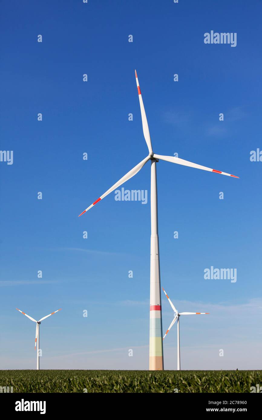Windmills in farmland producing green energy - deep blue sky Stock Photo