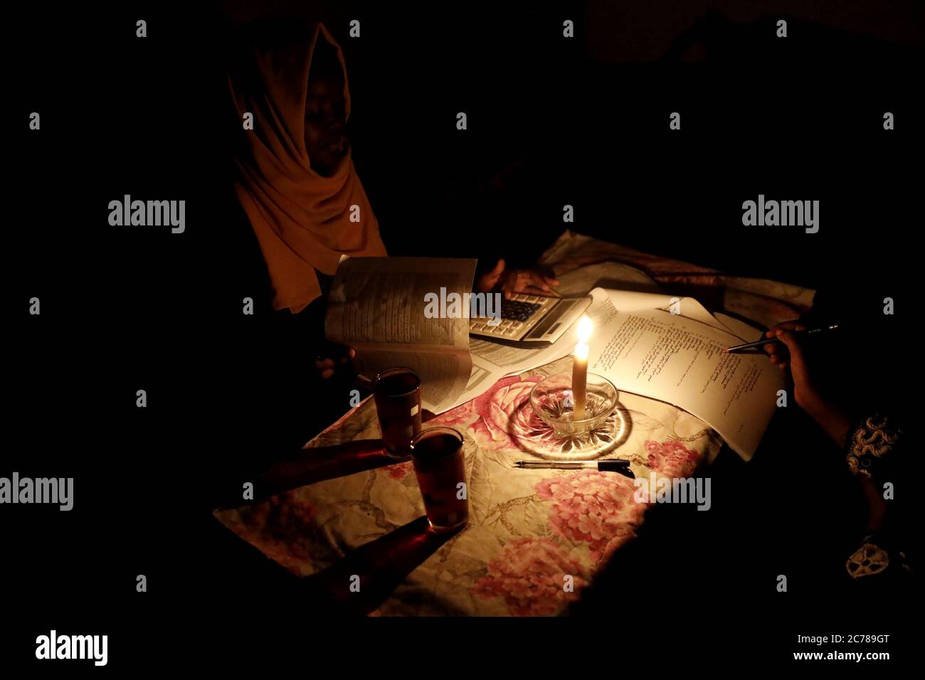 (200715) -- KHARTOUM, July 15, 2020 (Xinhua) -- A female student studies for the basic school certificate examinations under candle light after a blackout in her area under programmed power cuts in Khartoum, Sudan, July 14, 2020. (Xinhua/Mohamed Khidir) Stock Photo