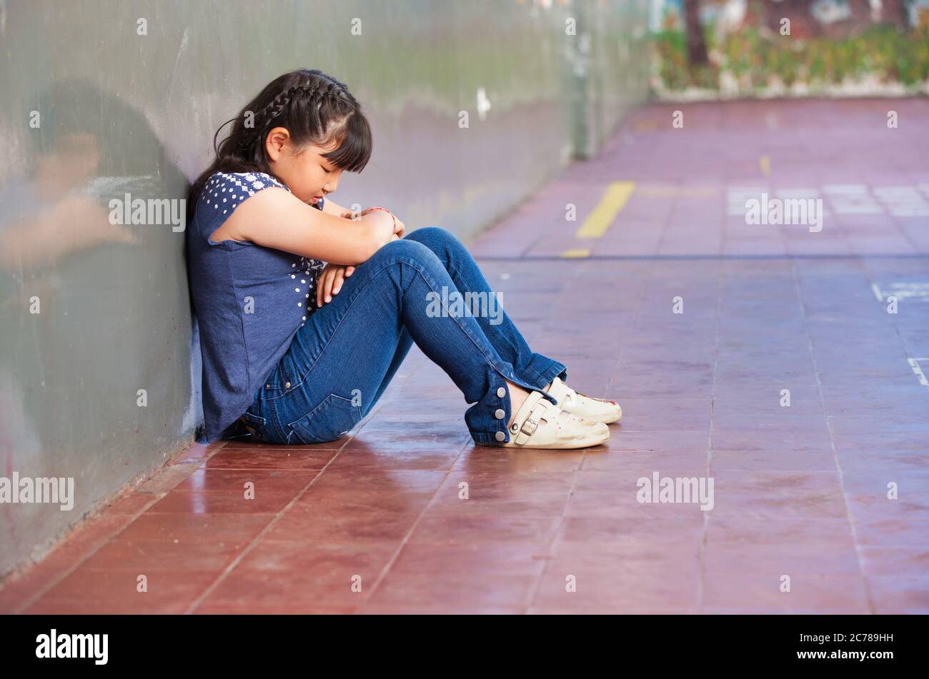 Elementary school scene. Asian girl bullied and sad. Stock Photo