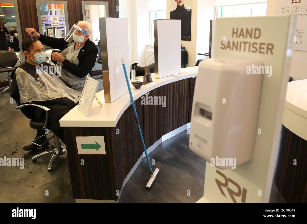 Hairdresser David Nicolson cuts William Paterson's hair at Rainbow Room