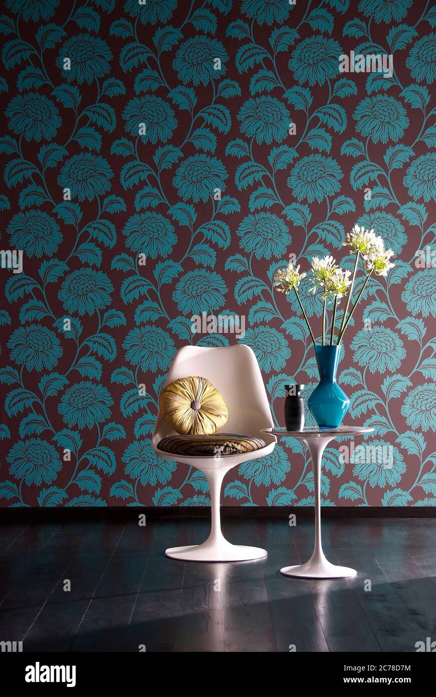 Shot of elegant chair with flower vase on side table in front of floral wallpaper wall Stock Photo