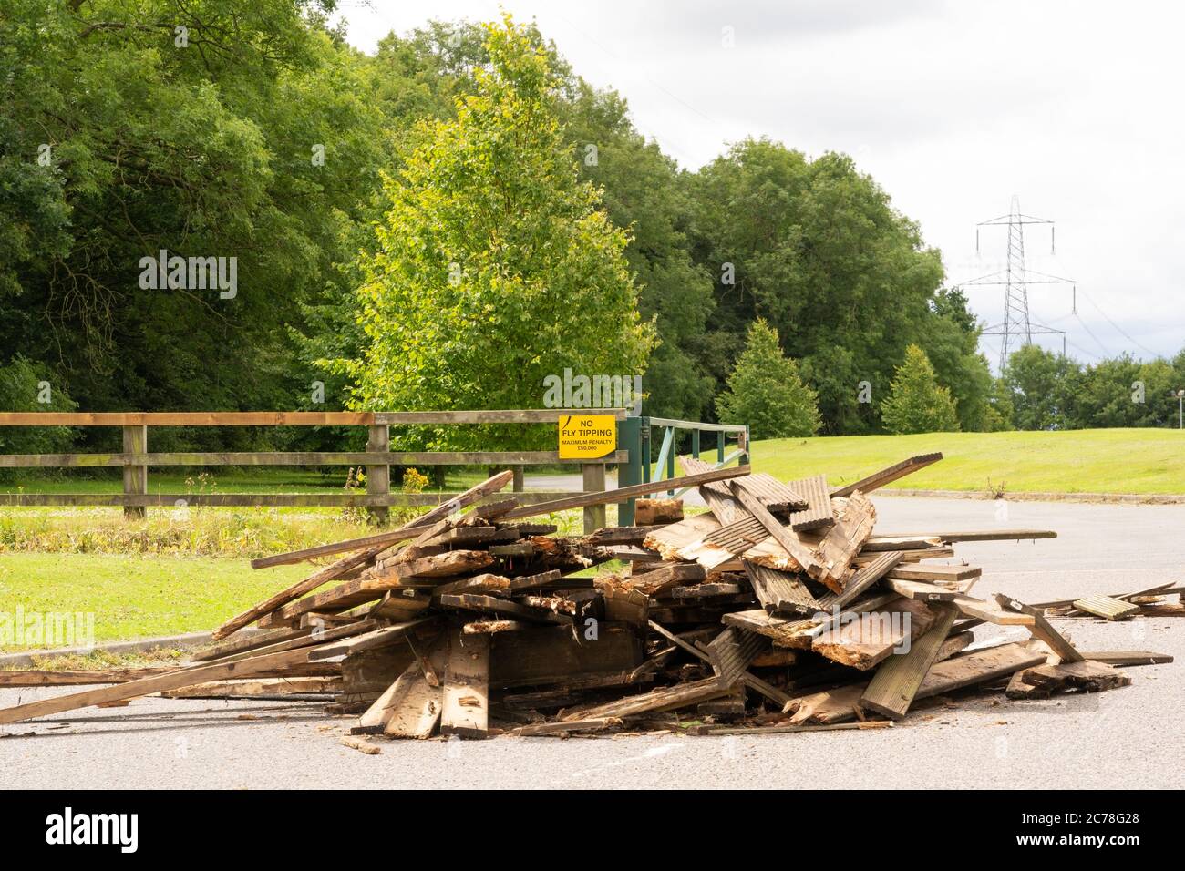 Illegal fly tipping and dumping of waste in a lane with a sign saying 'No fly tipping' in the background.  Bishop's Stortford, Hertfordshire. UK'. Stock Photo