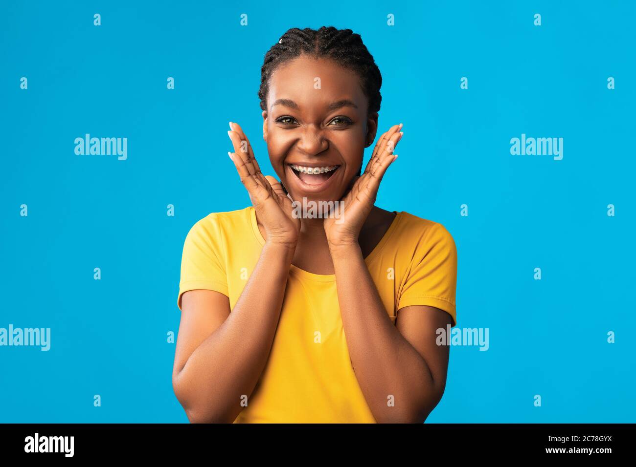 Excited Girl With Brackets Smiling To Camera Posing In Studio Stock Photo