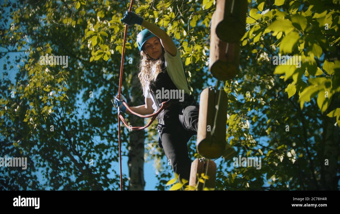 Woman Crossing Rope Woman crossing a construction of the rope and stumps - an entertainment ...