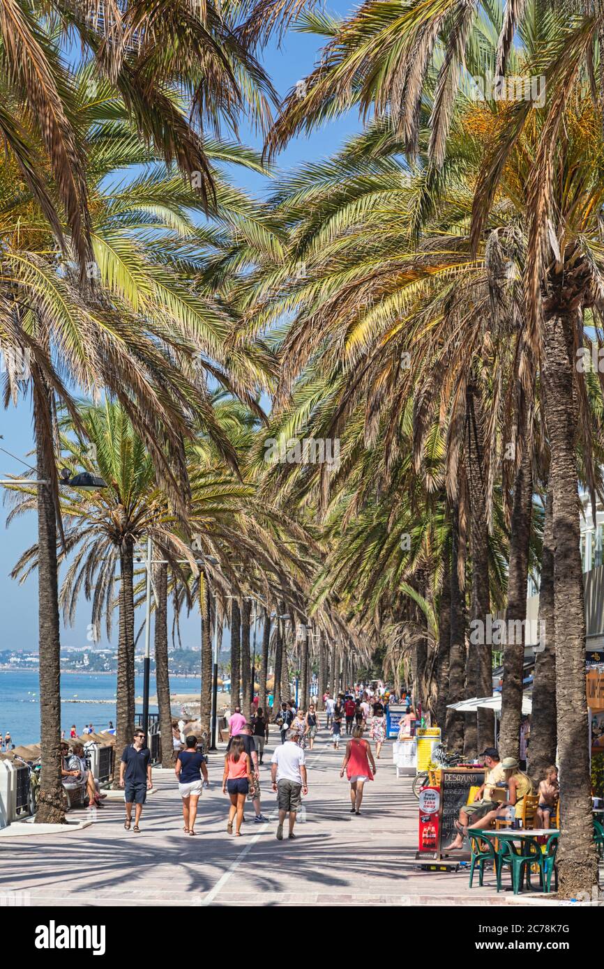 People strolling on the paseo maritimo, or seaside promenade, Marbella, Costa del Sol, Malaga Province, Andalusia, southern Spain. Stock Photo