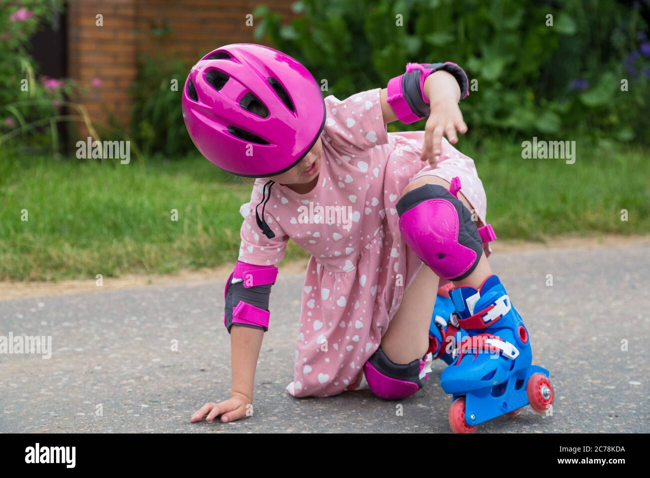 A little girl roller skating in full protection fell on the asphalt. The  concept of an active healthy lifestyle and safe riding Stock Photo - Alamy