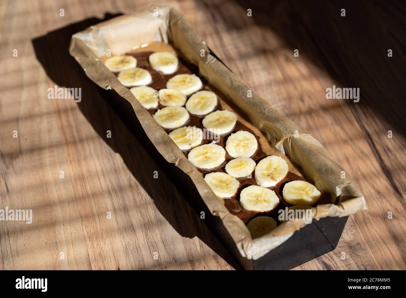 Dough of easy to prepare and healthy, home made banana bread – in baking form. Stock Photo
