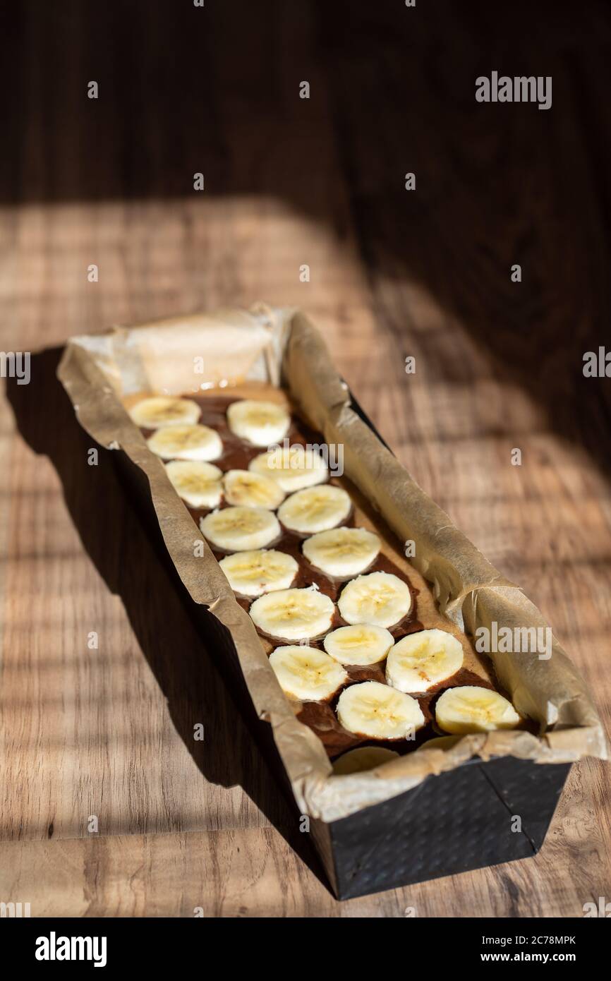 Dough of easy to prepare and healthy, home made banana bread – in baking form. Stock Photo