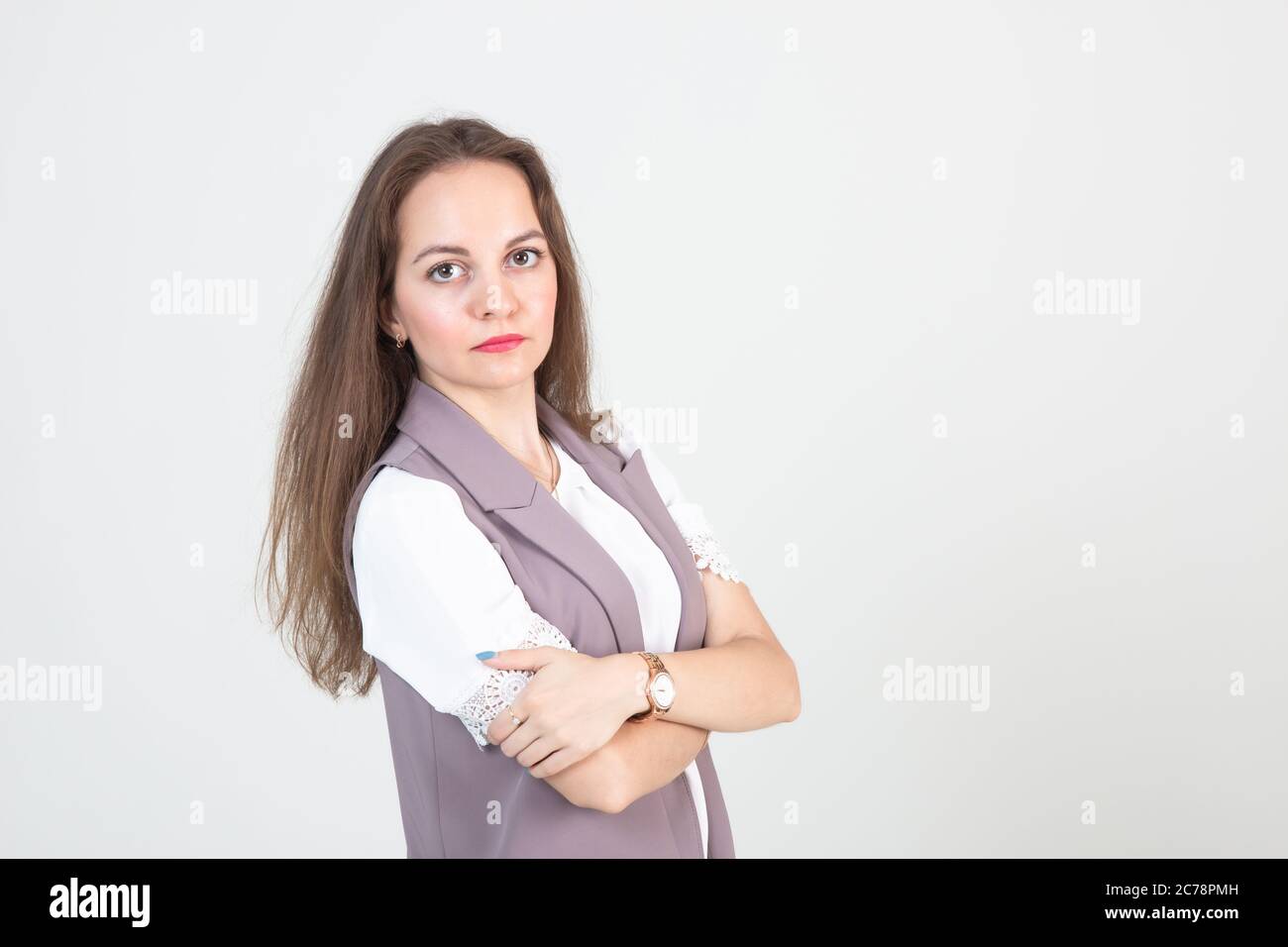 beautiful young woman in business strict clothes poses against a white wall Stock Photo