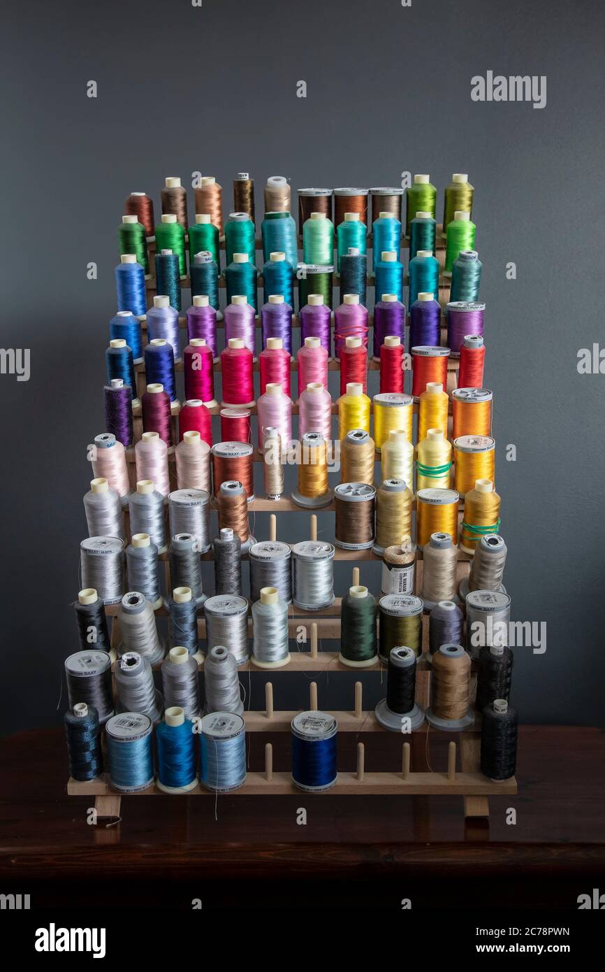 A spool  holder for storing up to 120 bobbins or reels of sewing thread and displaying a large selection of colours and varieties. Stock Photo