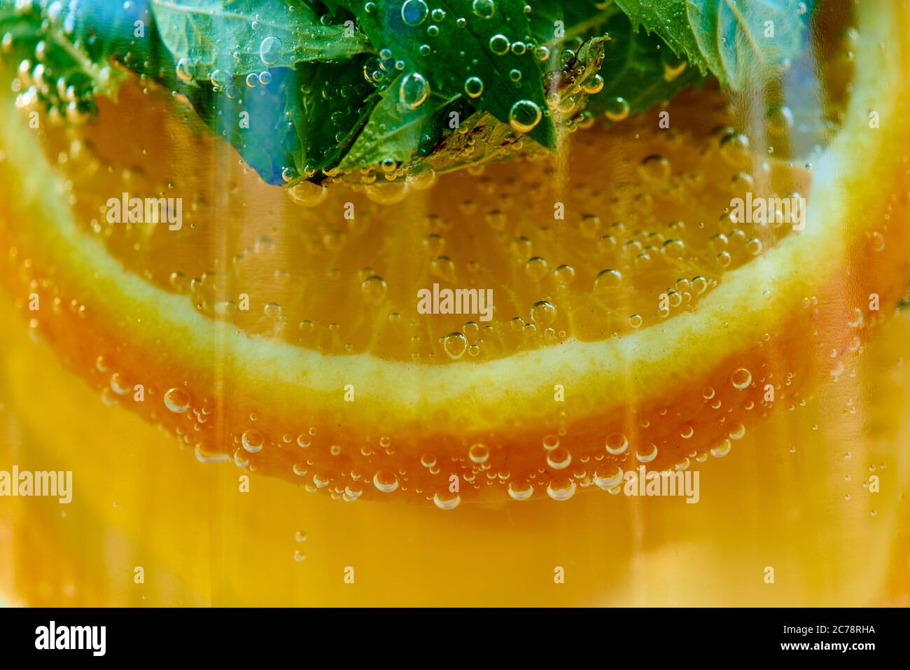 Orange lemonade with mint in a glass as a background. Stock Photo
