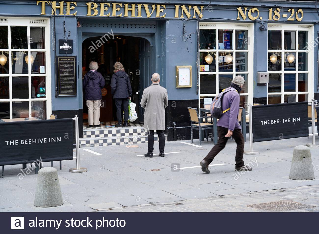 Edinburgh, Scotland, UK. 15th Jul 2020. Edinburgh pubs reopen today for bookings, socially distanced queues already forming, seen here at the Beehive pub in the Grassmarket on the first day back after the lockdown for Coronavirus Covid-19 pandemic. Credit: Craig Brown/Alamy Live News Stock Photo