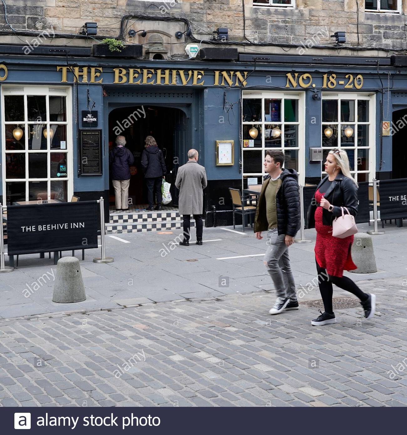 Edinburgh, Scotland, UK. 15th Jul 2020. Edinburgh pubs reopen today for bookings, socially distanced queues already forming, seen here at the Beehive pub in the Grassmarket on the first day back after the lockdown for Coronavirus Covid-19 pandemic. Credit: Craig Brown/Alamy Live News Stock Photo