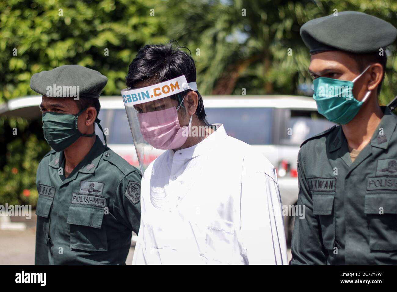A Muslim man wearing a face shield escorted by Islamic Sharia police who will flogged for violating Islamic Sharia law, was proven sexually abusing two boys in North Aceh District, Aceh Province, on Wednesday, July 15, 2020. A man violating Islamic law punished with 74 lashes. Aceh is one of the provinces with the largest Muslim majority population in the world that enforces Islamic Sharia law and people can be flogged from various violations, including adultery, Jarimah, gambling and drinking alcohol. (Photo by Aziz Abdi/INA Photo Agency/Sipa USA) Stock Photo