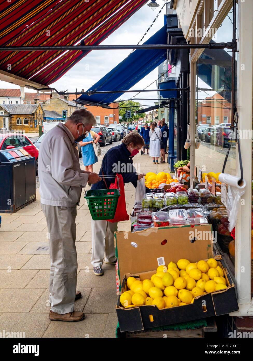 A man and a woman with face masks customers at a greengrocer and fruiterers shop in Stokesley North Yorkshire England UK Stock Photo